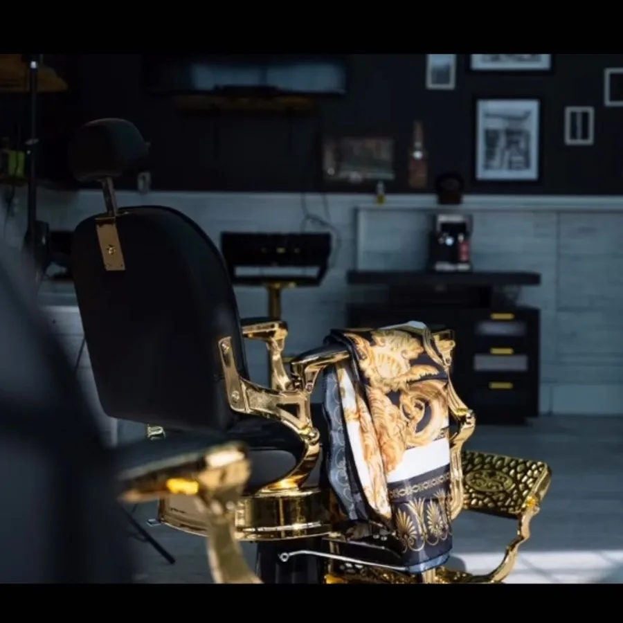 Gold-trimmed vintage barber chair in the dark interior of Prestige Gentleman Hair Studio
